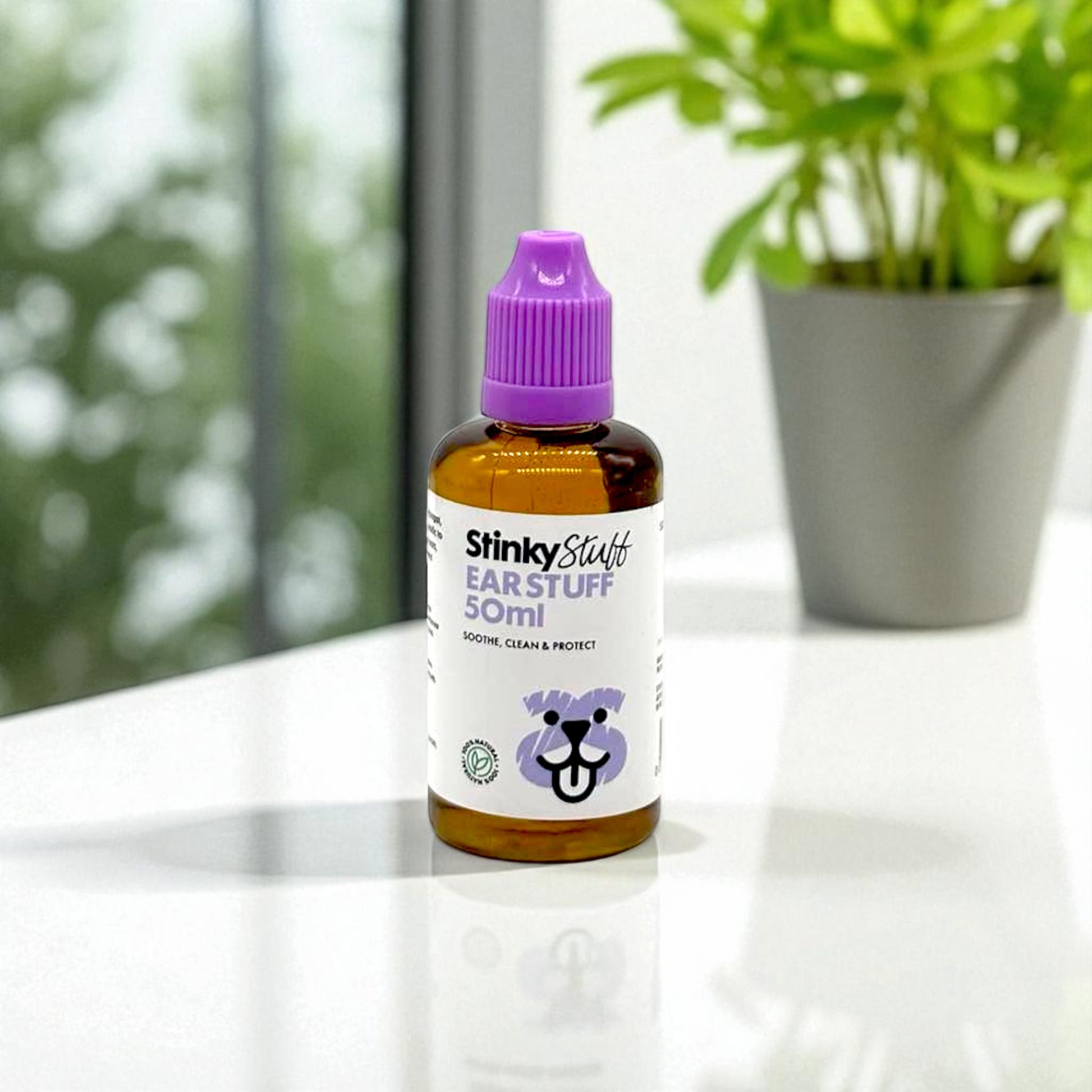 Bottle of Stinky Stuff Ear Stuff on a surface with a blurred background